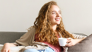 Young woman relaxing with tea on couch
