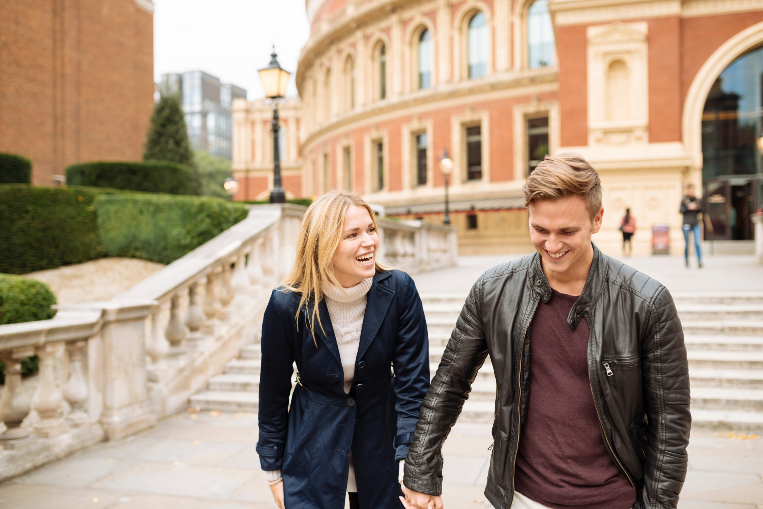 Young couple hand in hand outside Albert Hall, London, England, UK